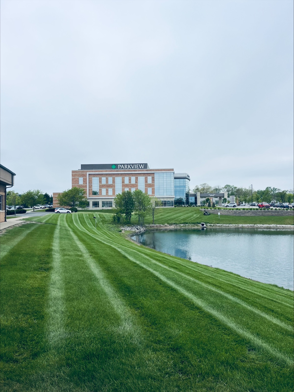 Striped commercial lawn surrounding a pond at a Fort Wayne medical property